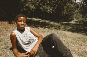 Woman lays in woods wearing environmentally and Reef-Safe, cool sunscreen that provides the best SPF for the face.